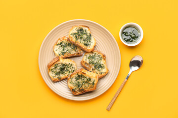 Plate with slices of toasted garlic bread and oil on color background