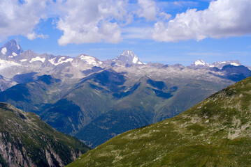Fototapeta na wymiar Beautiful mountain panorama seen from summt of Nufenen Pass on a sunny summer day. Photo taken July 3rd, 2022, Nufenen Pass, Switzerland.
