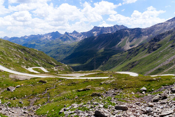 Fototapeta na wymiar Scenic view of Bedretto Valley, Canton Ticino, with mountain pass road of Nufenen Pass on a sunny summer day. Photo taken July 3rd, 2022, Val Bedretto, Switzerland.