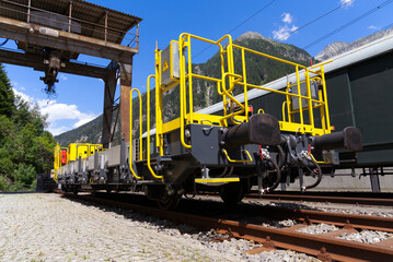 Cargo railway wagon with crane at railway station of mountain village Göschenen on a sunny summer...