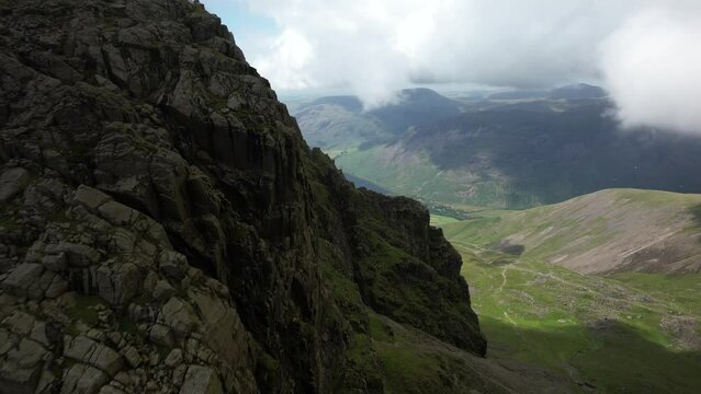 Beautiful view from Scafell Pike (highest mountain in England) towards Wast Water. Drone flying down from big mountain. Lake District National Park, by drone in 4K. Cinematic British scenery.