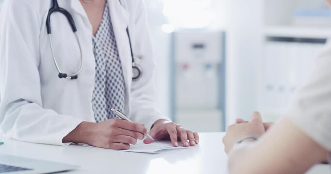 Doctor consulting, talking to patient about medical symptoms using a checklist form in a healthcare office or clinic. Closeup of a physician or gp giving advice on health in a checkup consultation