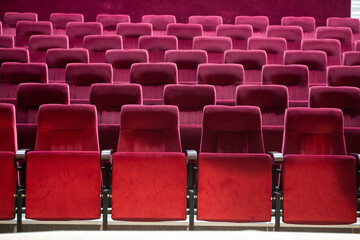 Empty red chairs for audience in the theater