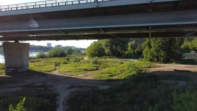 Aerial drone shot of under the bridge while a person carries and walks looking to vista river Warsaw Poland