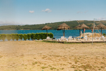 Natural solarium with deck chairs and straw parasols near the river