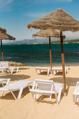 Deck chairs with straw parasols near the river