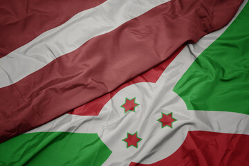 waving colorful flag of burundi and national flag of latvia.