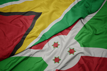 waving colorful flag of burundi and national flag of guyana.