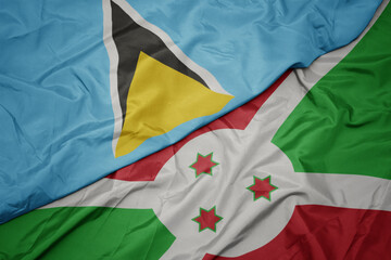 waving colorful flag of burundi and national flag of saint lucia.