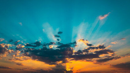 Sunset with grey clouds and light beams