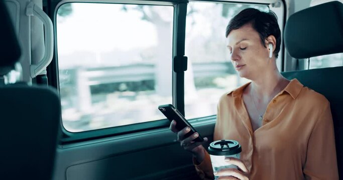 Businesswoman traveling, texting on phone and listening to music with wireless earbuds while taking the taxi to work. Professional female commute to work on a business trip while drinking coffee