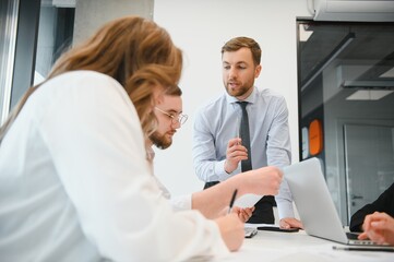 Obraz premium A group of business people partners during a set team meeting in the modern office. Teamwork concept