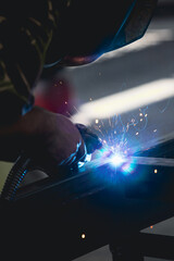 Industry worker welding iron pieces at work