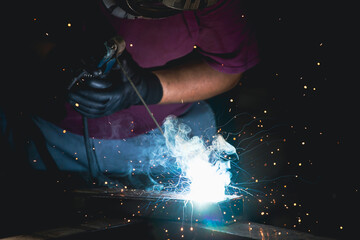 Obraz na płótnie Canvas Industry worker welding iron pieces at work