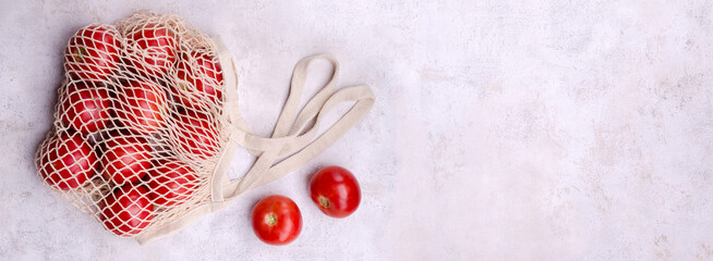 Large raw red tomatoes in a mesh bag