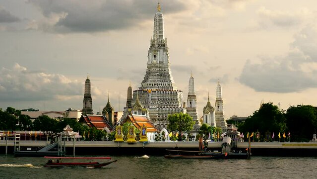 Boat traffic in front of Wat Arun Ratchawararam Ratchawaramahawihan, Temple of Dawn.  A Buddhist temple in the Bangkok Yai district of Bangkok, Thailand,  The most famous temple in Bangkok