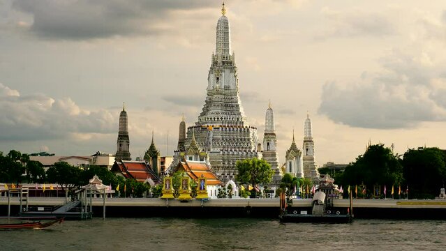 A water taxi motors past the Wat Arun Ratchawararam Ratchawaramahawihan, Temple of Dawn.  A Buddhist temple in the Bangkok Yai district of Bangkok, Thailand,  The most famous temple in Bangkok