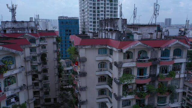 Old communist ,brutalist apartment building in Cho lon  or Chinatown district of Ho Chi Minh City, Vietnam. High angle looking down. Pan left over rooftops.