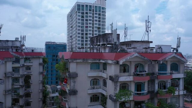 Old communist ,brutalist apartment building in Cho lon  or Chinatown district of Ho Chi Minh City, Vietnam. High angle looking down. Pan left from rooftops to city panorama.
