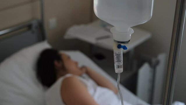 Pregnant woman on hospital ward in delivery room, selective focus. Dropper in hand of female at maternity hospital. Preparing for bring forth