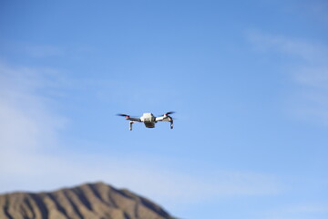 drone quadcopter with digital camera on blue sky