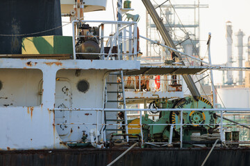 工業地帯の岸壁に着岸中の古びた内航船の船尾