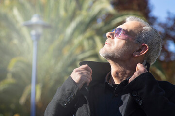 relaxed man with coat in autumn breathing fresh air and freedom