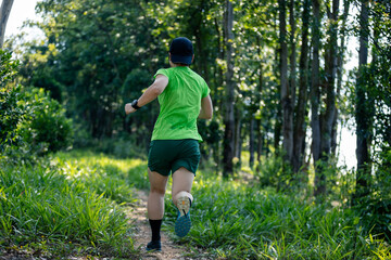 Obraz na płótnie Canvas Woman trail runner running at tropical forest mountain peak