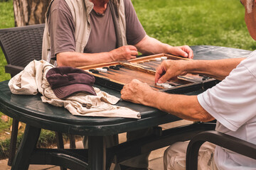 Board game of backgammon.Two old adult men playing backgammon in the street,hobby