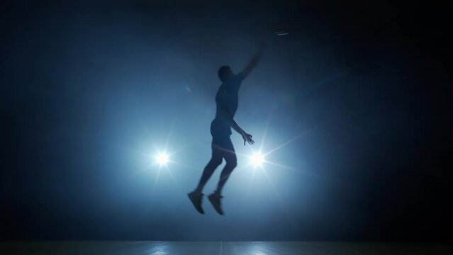 Sport lifestyle, caucasian volleyball player hits the ball towards the opponents, contour lighting, 4k slow motion.