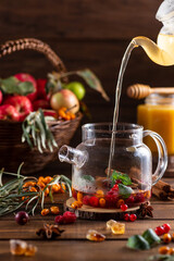 Boiling water is poured into a kettle with berries and spices