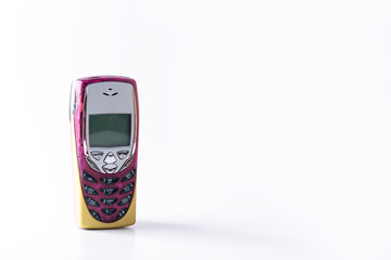 Plastic button retro mobile phone on a white background. Horizontal orientation, copy space.