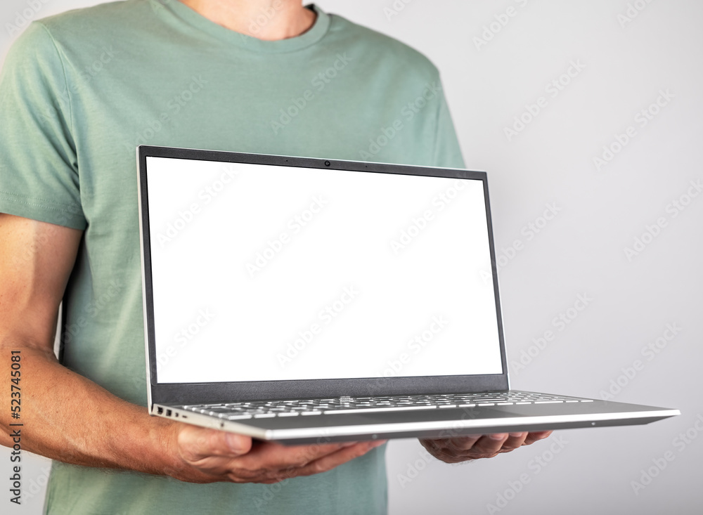 Poster Man holding laptop mockup with blank white screen. Male using computer for presenting information for work, study. Empty space for adding content. High quality photo