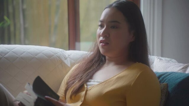 Portrait Of A Woman Reading Bible Inside Her Bedroom. Tilt-up