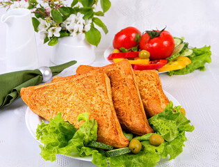 puff pastries stuffed with chicken meat, on a white dish with vegetables on a light background