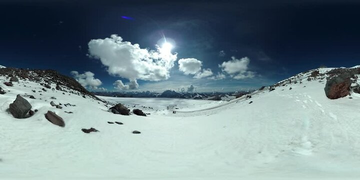 360 VR video of the snowy slopes of mount Elbrus at Caucasus Mountains. Tourists coming down the moutain. September, 2018