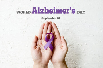 World Alzheimer's day. September 21. International Epilepsy Day. Hands holding purple ribbon on...