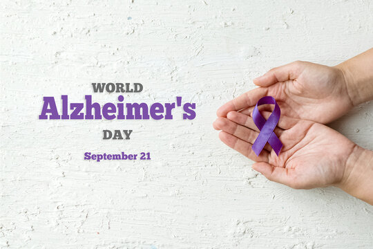 World Alzheimer's day. September 21. International Epilepsy Day. Hands holding purple ribbon on white background