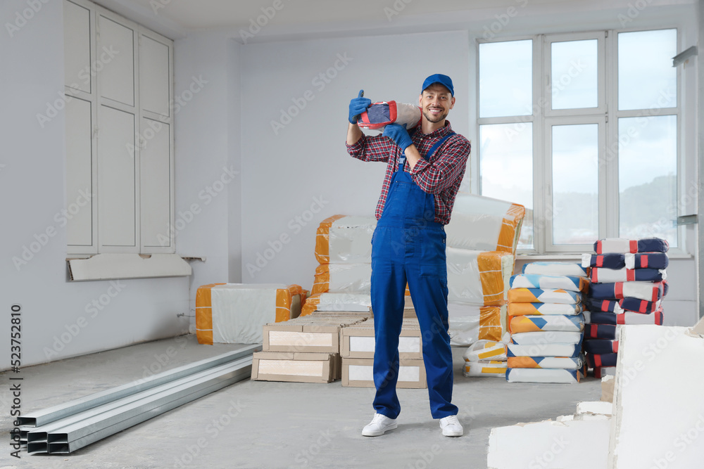 Poster Construction worker with new building materials in room prepared for renovation