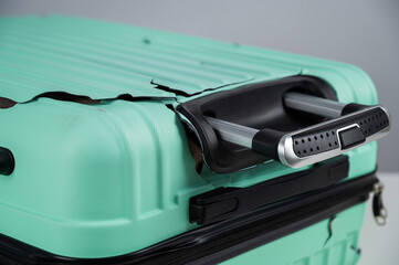 A close-up of a broken plastic suitcase.