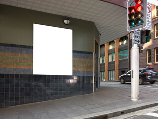Blank white mockup template for an advertisement board on wall at a street corner. Empty poster...