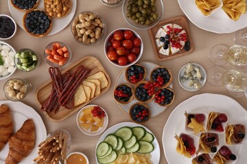 Variety of snacks on wooden table in buffet style, flat lay