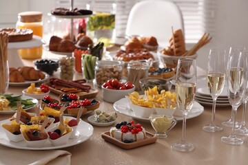 Variety of snacks on wooden table in buffet style indoors