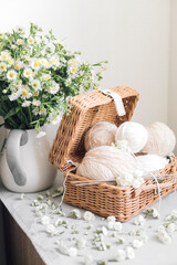 wicker basket with yarn and needles on white background.