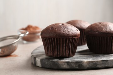 Delicious fresh chocolate cupcakes on grey table, closeup