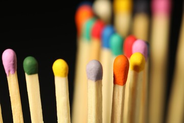 Matches with colorful heads on black background, closeup
