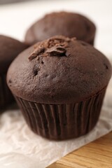 Delicious cupcake with chocolate crumbles on wooden board, closeup