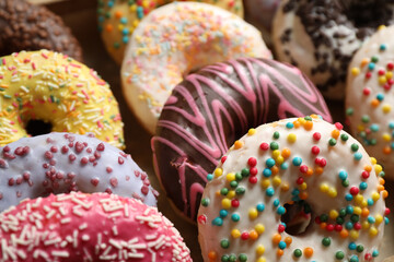 Yummy glazed donuts with sprinkles, closeup view