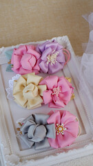 DIY projects handmade flowers made out of satin fabric for hair accessories. Handicraft with passion and patience with soft textile or fabric.