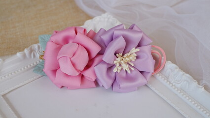 DIY projects handmade flowers made out of satin fabric for hair accessories. Handicraft with passion and patience with soft textile or fabric.